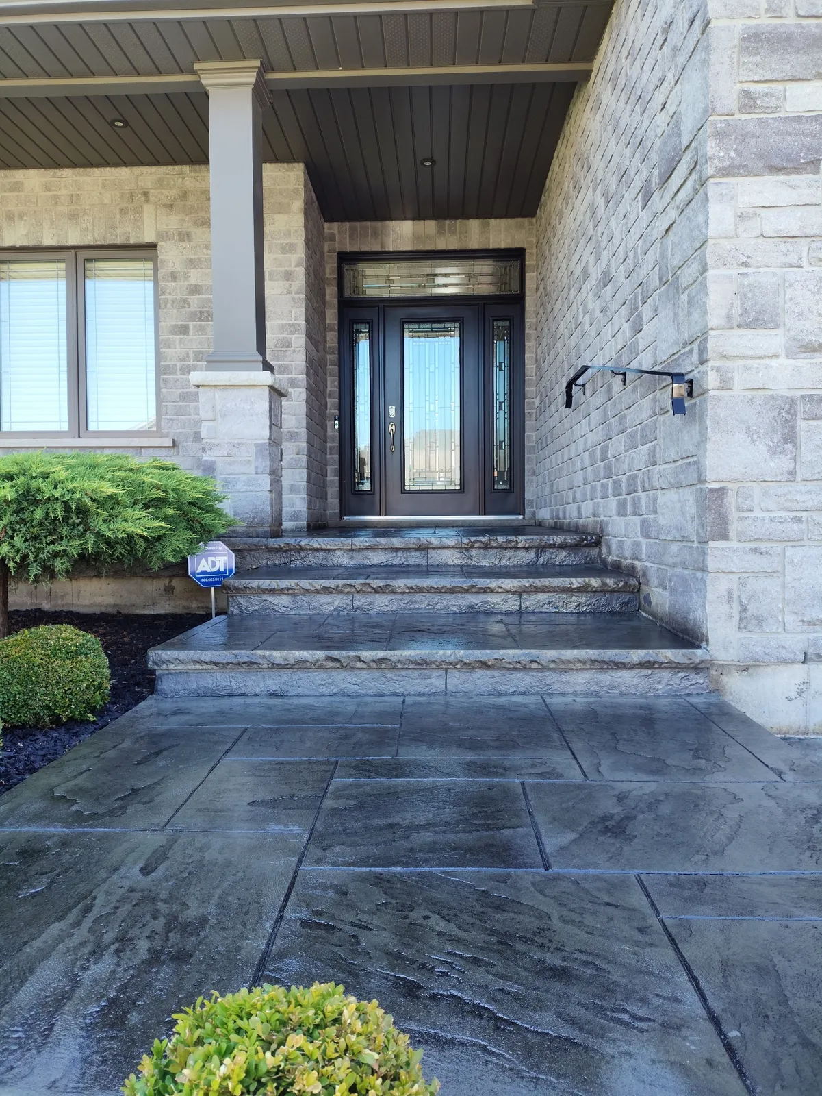 Freshly sealed stamped concrete entry steps and walkway in Tillsonburg